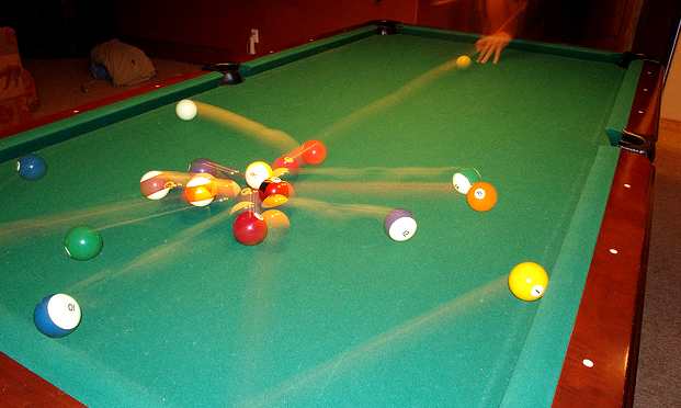 Photo of balls scattering on a pool table.