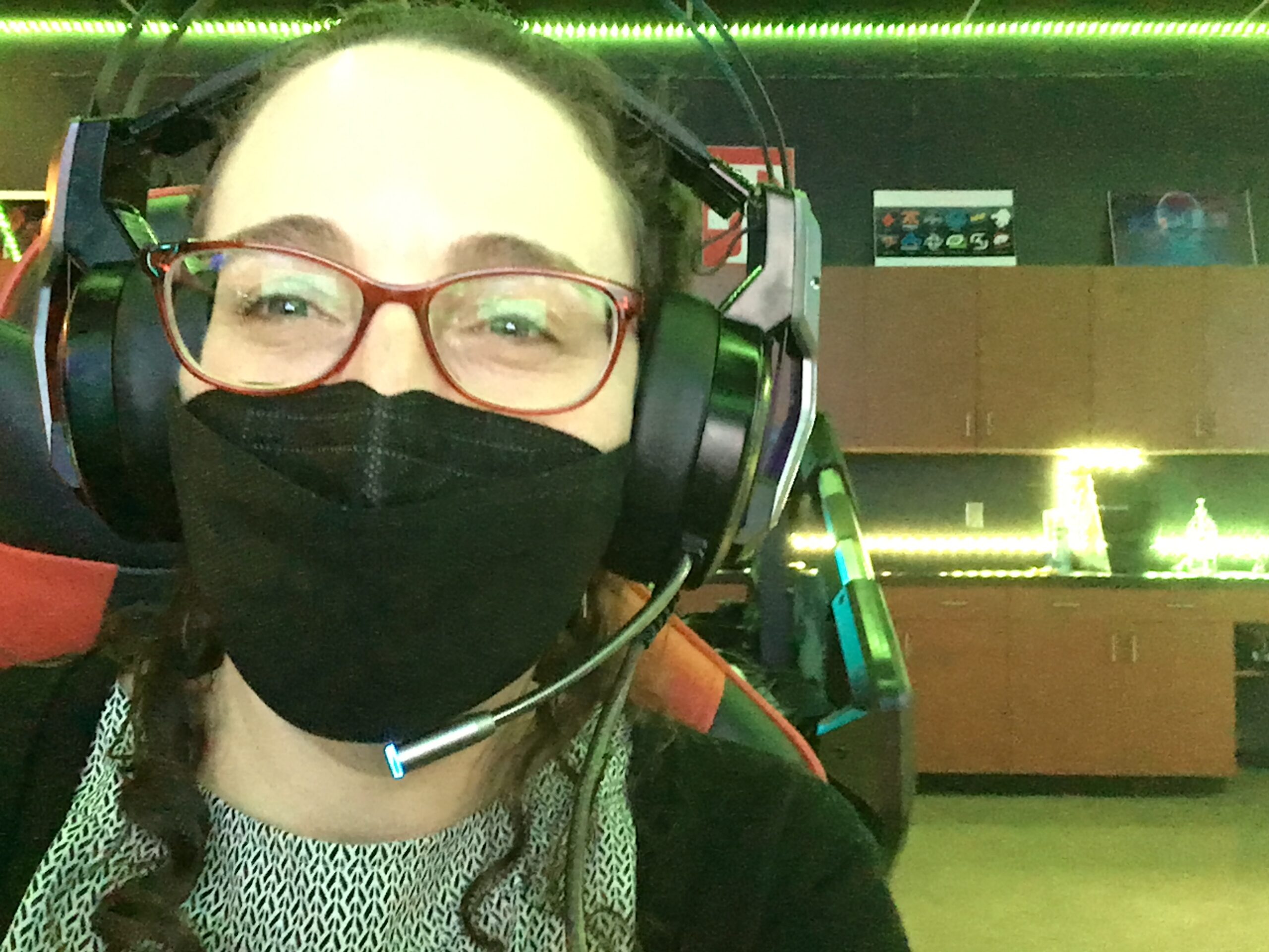 Shira Segal in close-up, wearing a face mask and a headset